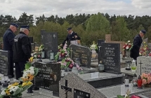 Czworo mężczyzn w mundurach strażackich na cmentarzu 