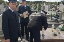 Troje mężczyzn w mundurach strażackich na cmentarzu 